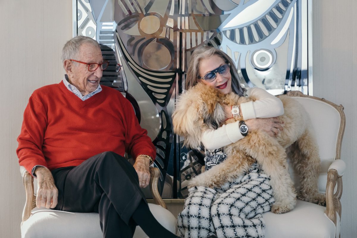 image of Man and Woman with Dog, smiling and loving. The woman is hugging the dog. 