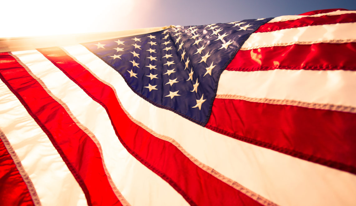 Closeup USA American flag,the symbolic of liberty,freedom,patriotic,honor,american family,kids,nation,independence day,4th of July blowing by the wind with overtoned color and selective focus