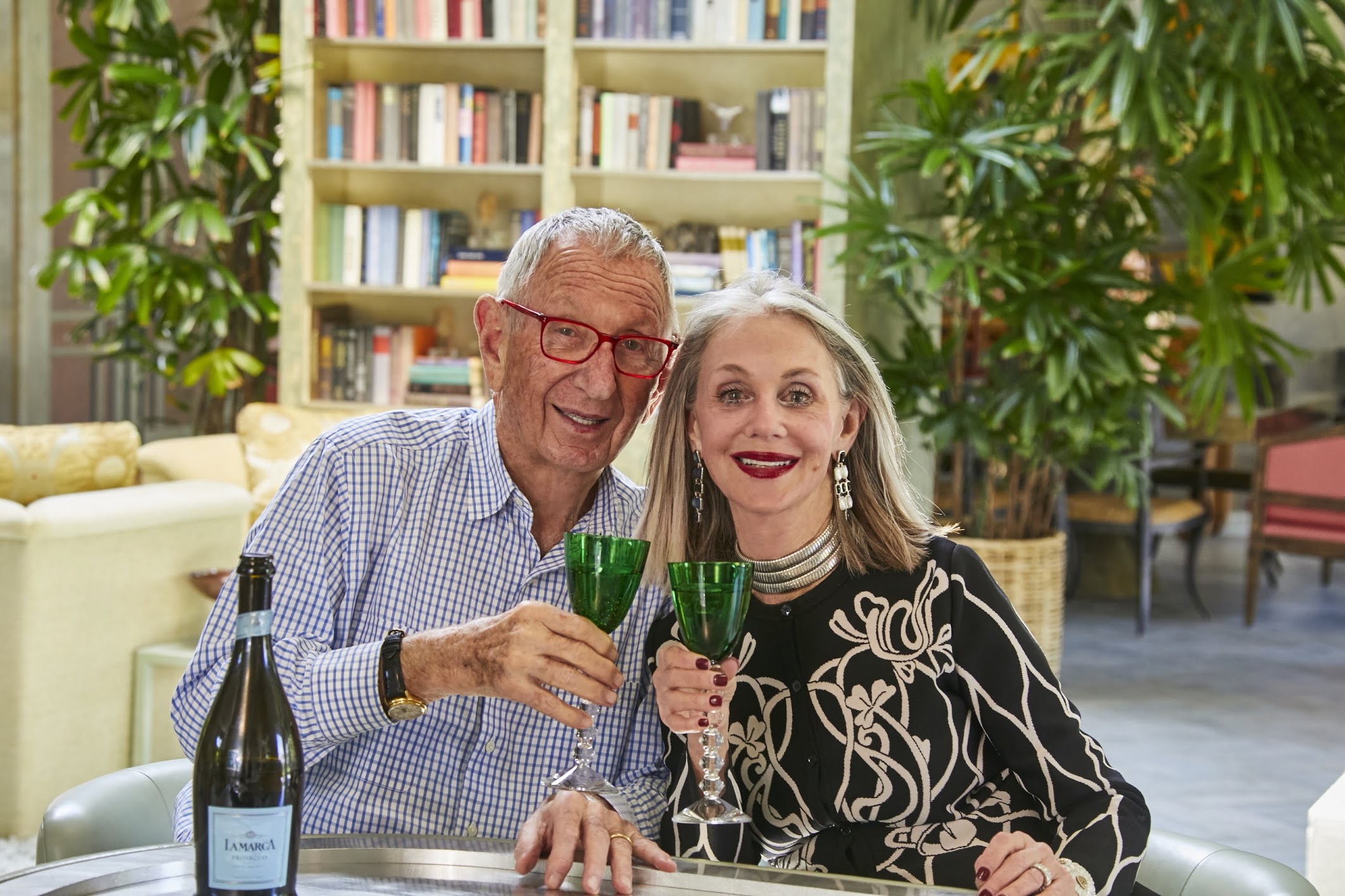 Mature couple holding up wine glasses in salute. Surviving holidays with in-laws.