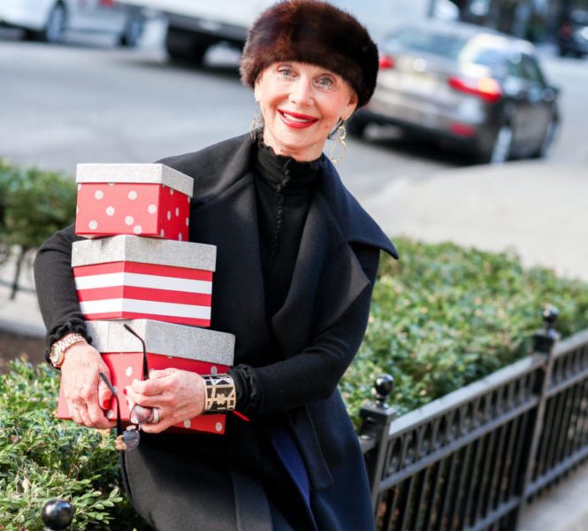 The Seasons of the Year, Honey Good smiling holding a stack of wrapped holiday gifts.