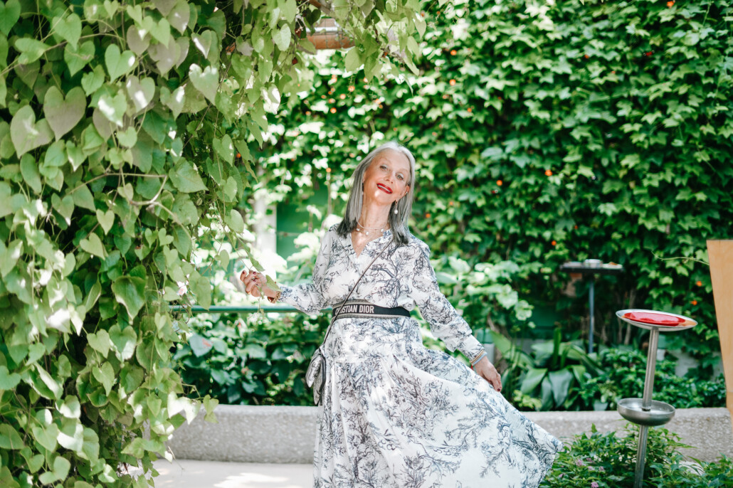 Honey Good shows how to improve self-confidence for women over 50, standing outside in garden in dress looking confident