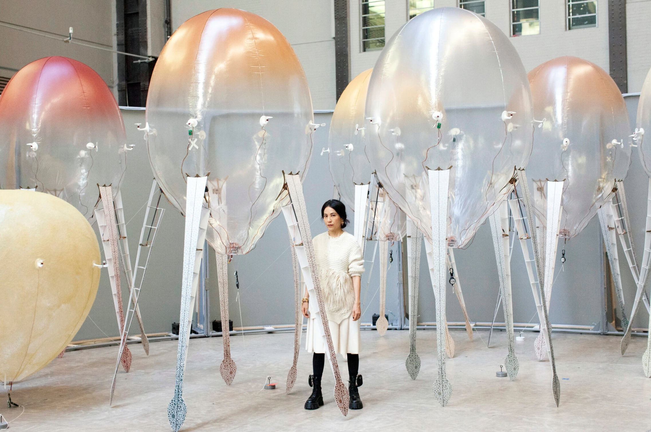Anicka Yi standing in her new exhibit with “biologized machines”