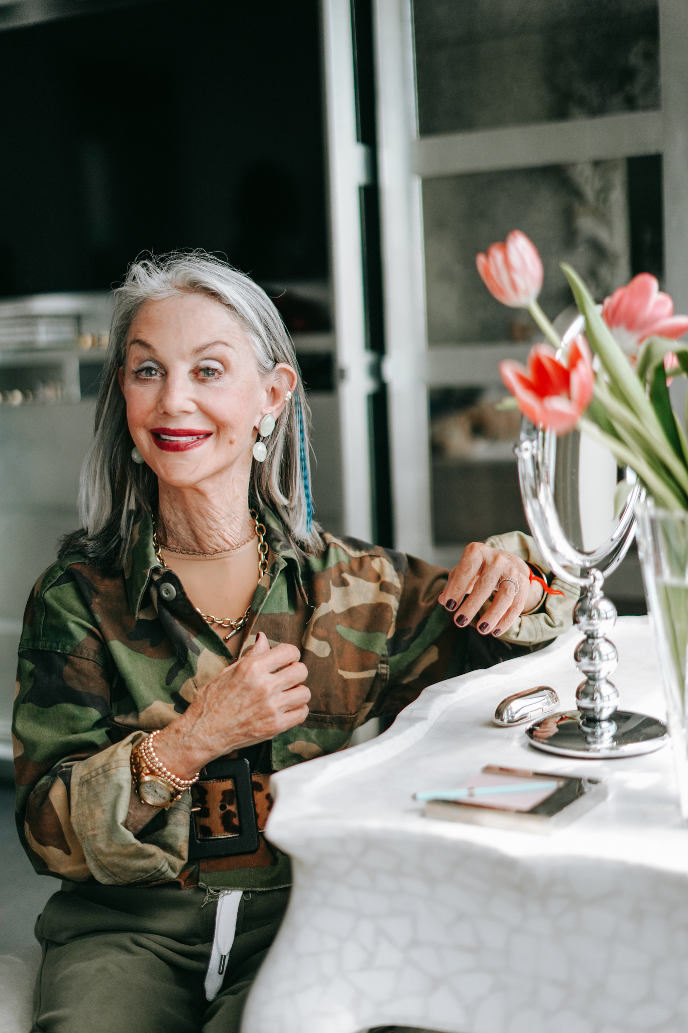 Honey Good smiling with signature red lipstick sitting at her vanity