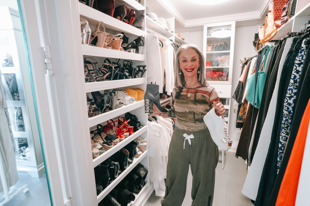 Honey Good holding shoes in her closet