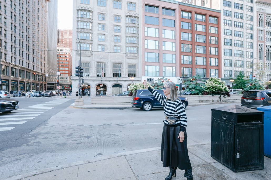 Honey Good hailing a taxi in Chicago, in front of downtown buidlings, finding purpose