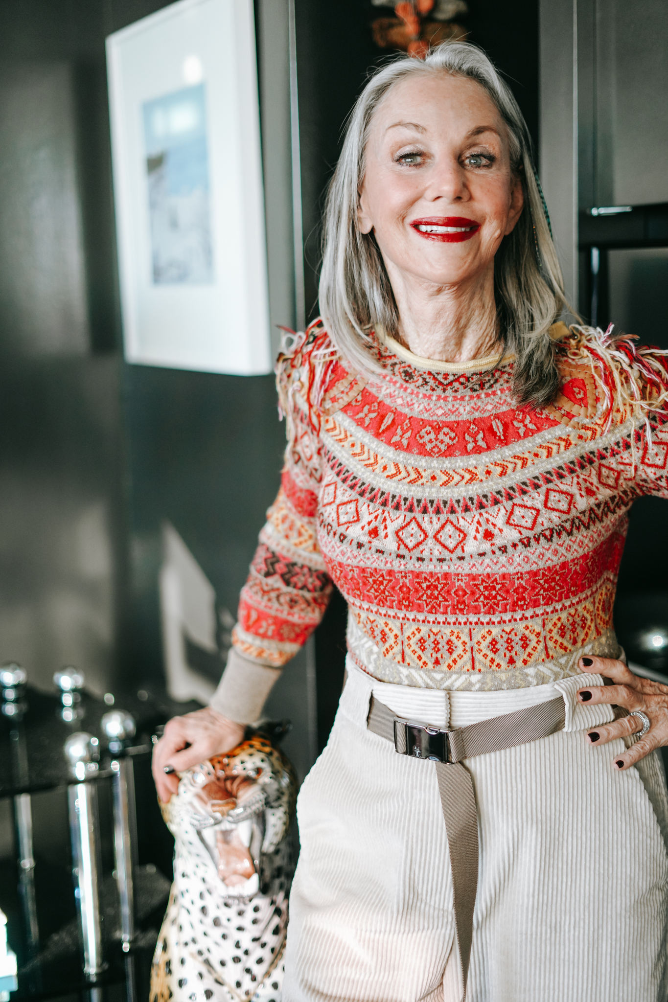 Honey Good smiling with her hand resting on porcelain leopard