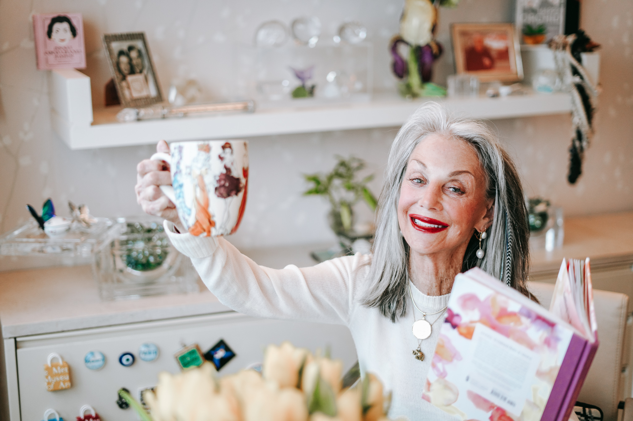 Honey Good with coffee mug, her book and smile