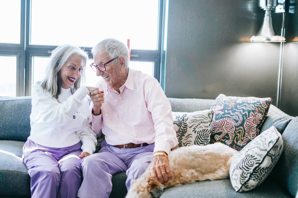 image of Honey, Shelly, and America Good, their dog, a wheaton terrier, on their sofa