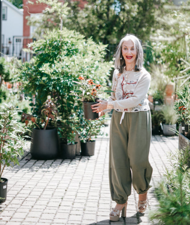 Honey Good holds a plant at a garden center signifying how you can become authentically you this spring 