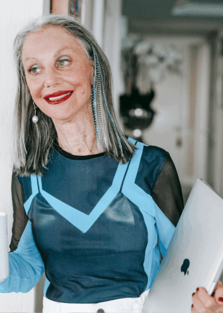 Honey holding her laptop and a cup of coffee